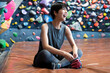 Portrait of a beautiful Asian woman smiling in front of a wall in a bouldering gym