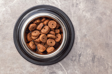 Poster -  Dry animal food. Dog or cat kibble isolated in bowl on wooden table.