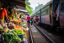 Train On Tracks Moving Slowly Through A Fresh Produce Market On The Railroad Tracks, Mae Klong Train Station