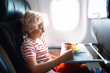 Child in airplane. Kids fly. Children flight meal