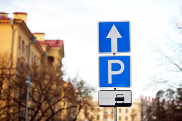 Wall Mural - Parking sign with arrow pointing direction, parking lot sign on pole in the city. Parking problems