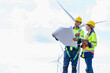 © AU USAnakul - Technician engineer worker builders looking for wind turbine blueprint drawings for wind turbine construction at windmill field farm. Alternative renewable energy for clean energy concept.