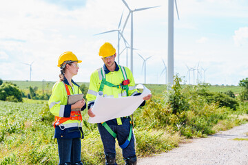 Wall Mural - Technician engineer caucasian worker builders looking for wind turbine blueprint drawings for wind turbine construction at windmill field farm. Alternative renewable energy for clean energy concept.