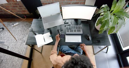 Wall Mural - over head of african american man podcasting at home, slow motion