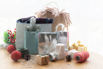 Wall Mural - Christmas festive shopping and sale concept. Paper bags with different goods and bright Christmas decorations on the table close up.