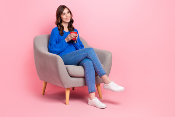 Poster - Full body portrait of cute creative lady sit soft cozy chair hold fresh coffee cup look empty space isolated on pink color background