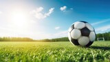 Fototapeta Sport - A soccer ball lies on the green grass