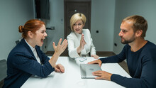 Blond, Red-haired Woman And Bearded Man In Suits In The Office. Business People Are Swearing During Negotiations In The Conference Room. 