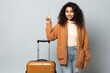 Indian woman ready to go to travel indicates with both forefingers up showing an isolated background studio generative ai 