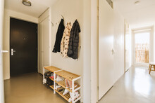 Hallway with closed door and coats hanging over shoe rack