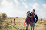 Fototapeta  - Young couple having a stroll on a grassland in the countryside