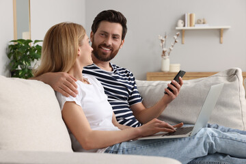 Sticker - Happy couple with laptop on sofa at home