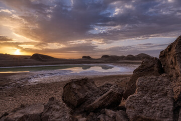 A Sulfur lake with sand rocks reflections in sunrise.