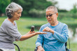 © M+Isolation+Photo - Asian people mature husband and wife, one in wheelchair, savoring peaceful outdoor moments in garden. Love and togetherness in midst of nature beauty. long live togetherness, valentine, insurance