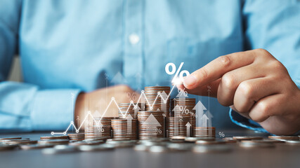 Businessman is calculating income and percentage return on investment. Concepts of interest rates and dividends Stack of coins with trading charts in financial and business stock growth trends.