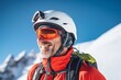 Portrait of smiling man climber in safe ski helmet and goggles on snow mountain at sunny day