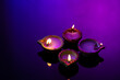 Close up of four diwali candles with copy space on purple background