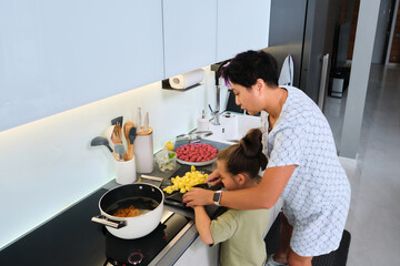 Grandmother and granddaughter are preparing soup.