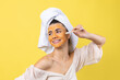 © Budjak Studio - A cute young girl with a scrub mask on her face brushes her teeth against a yellow background.