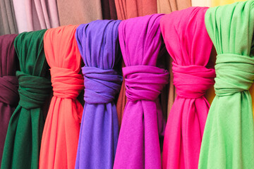 Poster - Mix colorful hanging vertical stripe textile, fabrics, cloths on the rack. Texture of multicolored fabrics close up.
