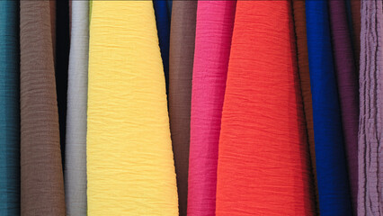Poster - Mix colorful hanging vertical stripe textile, fabrics, cloths on the rack. Texture of multicolored fabrics close up.