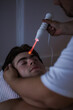 © Alex Vog - Doctor therapist doing electric toque amperage face anti-aging massage for man patient, rejuvenating massaging. Athletic guy visit masseur in medical office. Rehab massage concept. Copy ad text space