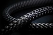 Black snake skin like cable Black braided wires in bundle on black background Wire sleeve for data line protection Flame retardant nylon tube