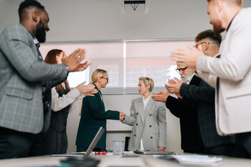 Wall Mural - Portrait of businesswoman handshaking female partner at group meeting making business agreement deal, concluding trust partnership contract, applause and partnership success for financial deal.