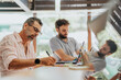 © qunica.com - Successful professionals in diverse team work together in an office, sharing ideas and optimizing their marketing strategies for customer engagement.