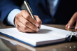 © ty - Businessman hand writing in a notebook with a pen