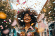 poc woman surrounded by confetti celebrating and happy , from low angle