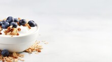 Healthy food concept Breakfast yogurt bowl with granola blueberries and maple syrup on gray background from above with empty space