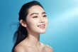 © Viewvie - Beautiful asian woman smile with clean fresh skin on blue background.