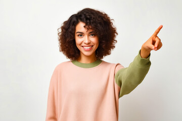 Poster - Woman with curly hair is smiling and pointing to the side.