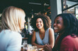 © Jasmina - Happy smiling female friends sitting in a café laughing and talking during a lunch break