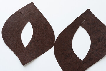 Sticker - rounded brown paper pieces arranged to form irregularly shaped eye-frames on white