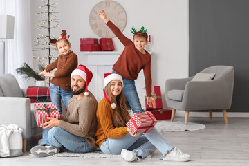 Sticker - Happy parents and their little children with Christmas presents at home