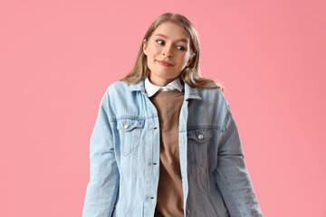 Wall Mural - Young woman shrugging on pink background