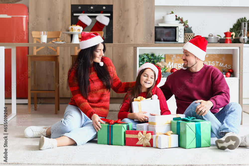 Happy family with Christmas presents in kitchen