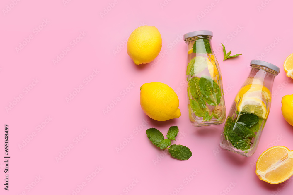 Bottles of tasty lemonade with mint on pink background