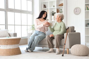 Sticker - Senior woman taking glass of water from her daughter at home