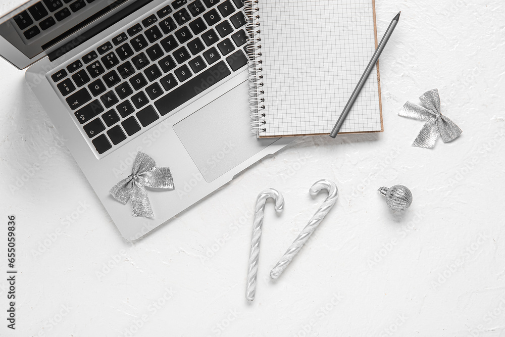 Laptop with notebook and Christmas decor on white background