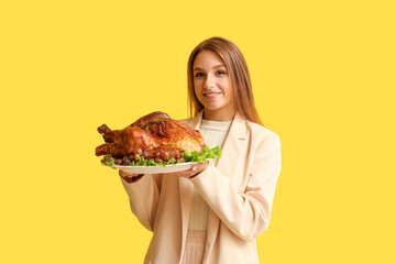 Sticker - Young woman with tasty turkey on yellow background. Thanksgiving Day celebration