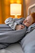 © alfa27 - Young redhead ginger woman covered with warm blue blanket sleeping in bed at home, close up portrait side view free spare time lifestyle resting time