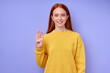 © alfa27 - beautiful redhead happy cheerful girl, teacher showing number 4 on blue background. Sign language alphabet. free education for deaf children, girl demonstrating three fingers