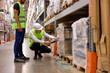 © alfa27 - Manager and supervisor taking inventory in warehouse, male workers in uniform talking, discussing, good job teamwork. confident and concentrated guys in working uniform vest and hardhat