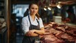 a female worker standing in front of a shelf with raw meat. Butcher working in a modern butcher shop