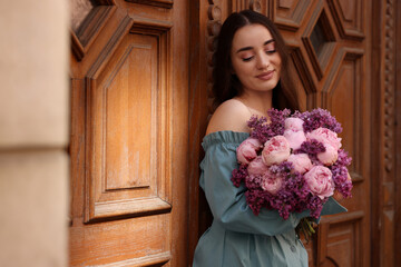 Sticker - Beautiful woman with bouquet of spring flowers near building outdoors, space for text