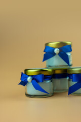 Wall Mural - Scented candle wrapped with bow blue wedding gifts favors for guests. Close up