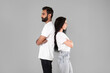 © Prostock-studio - Offended middle eastern couple ignoring each other standing, gray background